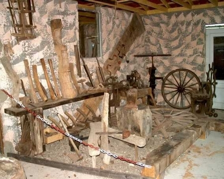 Anciennes machines agricoles en bois exposées à l’Office de Tourisme Cœur de