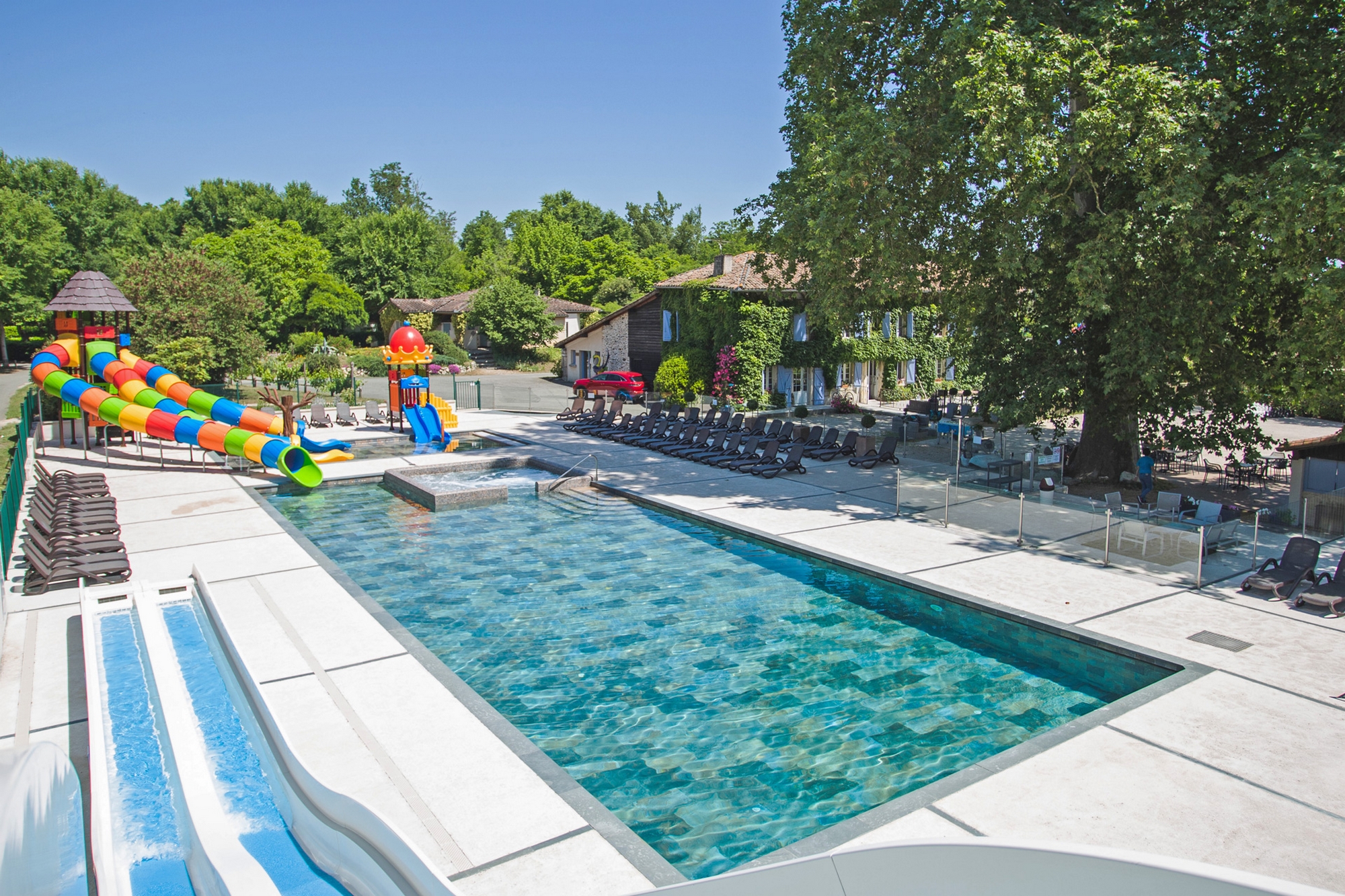 Piscine avec toboggans aquatiques et espace détente en Cœur de Garonne